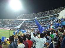 Fans holding blue deccan chargers flags in stadium