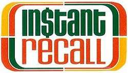 A logo for the American television game show Instant Recall, featuring green and orange letterface and a dollar sign in place of the "s" in "Instant".