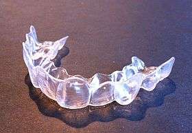 A clear plastic device in the shape of teeth