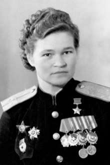 Photo of Sebrova wearing her medals including her guards pin, Order of the Red Star and an Order of the Patriotic War on the right side of her chest (left in image); on the other side her Hero of the Soviet Union Gold Star is pinned above the first row of four medals with her Order of Lenin and three orders of the Red Banner. Two campaign medals, one for the defense of the Caucuses and one for Victory over Germany are below the row of Orders of the Red Banner.