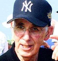 Irving Schwartz, wearing a New York Yankees baseball cap.