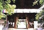 Small wooden gate with two guardian statues in the outer bays.