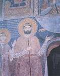Medieval mural portrait on the interior walls of a church depicting a tall bearded man in a noble's attire