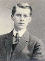 Waist high portrait of man in his teens wearing a suit, leaning to his left so his right shoulder is cut off