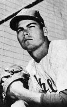 A black-and-white photograph of a man wearing a white baseball uniform, pinstriped, with "Phillies" across the chest in script, and a dark-colored baseball cap with a white "P" on the front