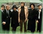 Six adults outdoors, in funeral clothing