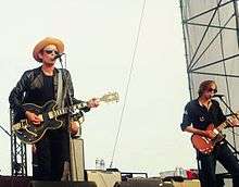 Jakob Dylan and Stuart Mathis playing guitar and singing onstage