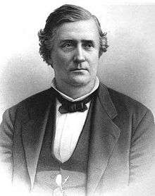 Back and white drawing of a white man wearing a white shirt, dark bow tie, and dark jacket and vest
