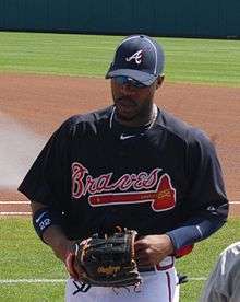 Jason Heyward on a grassy field, wearing a Braves uniform and holding a baseball glove