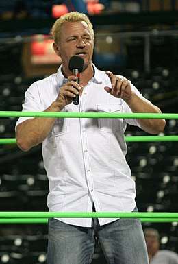 Jeff Jarrett, a blond-haired Caucasian man using a microphone to speak to a crowd