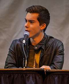 The image is of a young man talking into a microphone