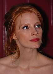 A shot of a red-haired woman as she looks away from the camera