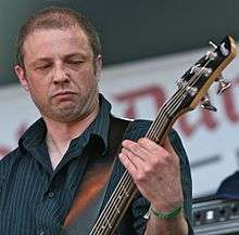 A close-up of Diarmuid Dalton playing bass during the day
