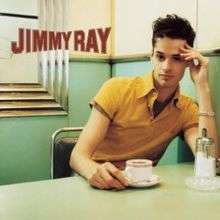 The cover features the artist at a diner, wearing a light orange t-shirt with the buttons open, showing a brown shirt under it. He has his left hand on the side of his forehead and his right hand next to a coffee cup on a saucer plate. The artist's name appears on the left side of the cover.