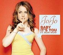 The cover has the artist against an orange background, putting her right index finger to her mouth. Next to the artist is a white box containing the artist's name logo, the song title and the featured artist's name, all colored in orange.