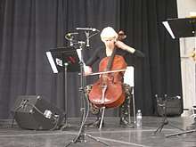 Jeanrenaud, seated, playing cello, with electronics