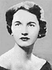 A black and white photograph of a formally dressed woman with short, dark hair