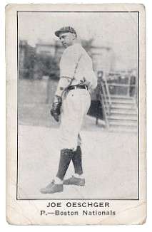 A man wearing a white old-style baseball uniform and dark baseball cap