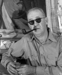 Black-and-white photograph of John Ford smoking a pipe.