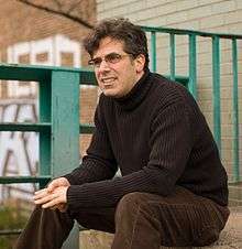 The author Jonathan Lethem, sitting on the bank of the canal