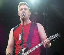 Josh Homme playing guitar onstage