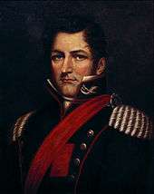 Half-length painted portrait depicting a man with dark blond hair wearing a military tunic with gold epaulets, red piping, a red sash and upraised collar bearing cavalry insignia