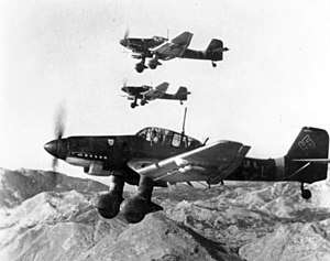 Black and white photograph of aircraft flying with mountains in the background
