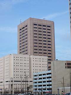 Street level view of group of buildings with tower, jail, parking garage