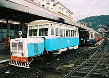 Aquamarine-and-white railcar at a station