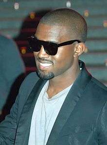 Kanye West in a dark jacket with black sunglasses.