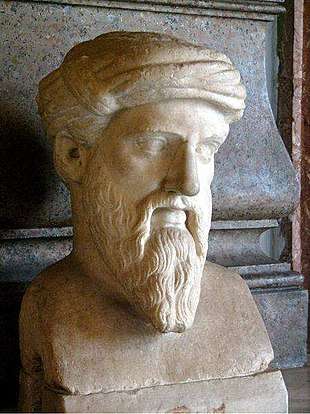 Marble bust of a man with a long, pointed beard, wearing a tainia, a kind of ancient Greek headcovering in this case resembling a turban. The face is somewhat gaunt and has prominent, but thin, eyebrows, which seem halfway fixed into a scowl. The ends of his mustache are long a trail halfway down the length of his beard to about where the bottom of his chin would be if we could see it. None of the hair on his head is visible, since it is completely covered by the tainia.