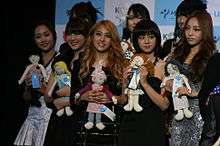 A group of five girls each holding dolls
