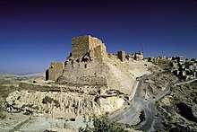 A castle built of stones on a cliff near a settlement