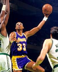  A man, wearing a purple jersey with the word "LAKERS" and the number 33