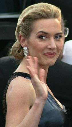 Kate Winslet smiles and waves at the camera.