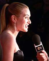 A profile view of Winslet as she speaks into a microphone.