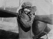 Katherine Stinson standing jauntily in front of an aircraft