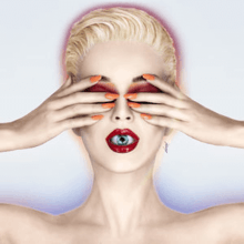 Katy Perry with blonde short hair. She covers her eyes with her hands; an eyeball is visible inside her mouth as her lips are slightly parted.