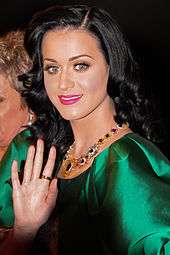 A picture of a woman wearing a green metallic dress and long black hair