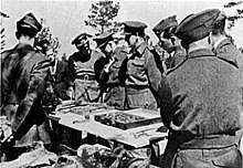 Eight soldiers in World War&nbsp;II-era uniforms, as per caption