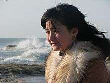 Young woman in a fur coat near the Caspian Sea