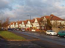 A row of suburban houses with white gabled ends and black timber beams