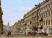 A photochrom print (color photo lithograph) showing Nikolayevskaya street and the facade of the hotel "Continental" in Kiev on a sunny day