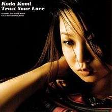 A close-up of a Japanese woman (Kumi Koda) with the song title and artists' name in the top left corner.