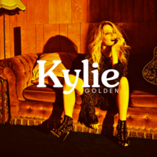 Minogue sitting on a couch, next to a guitar with her name and the album title placed in the center.