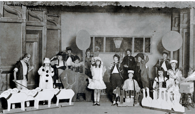 photograph of a stage filled with children costumed as toys