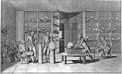 Black and white engraving of Lavoisier's laboratory, man seated at left with a tube attached to his mouth, man at center conducting experiment, woman seated at right drawing, other people visible