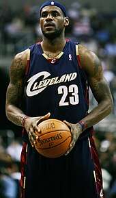 LeBron James in a Cleveland Cavaliers uniform, holding a basketball