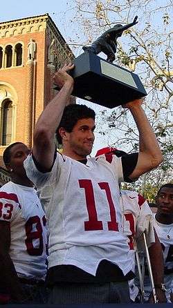 =Matt Leinart holding a championship trophy above his head in 2005