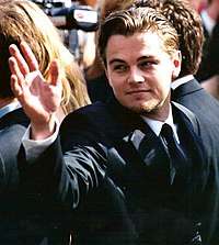 A picture of Leonardo DiCaprio with his hand raised.
